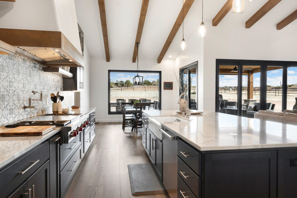 Galley-kitchen-open-floor-plan-steel-frame-home-interior-with-faux-beams-ceiling-and-wide-plank-wood-floors-