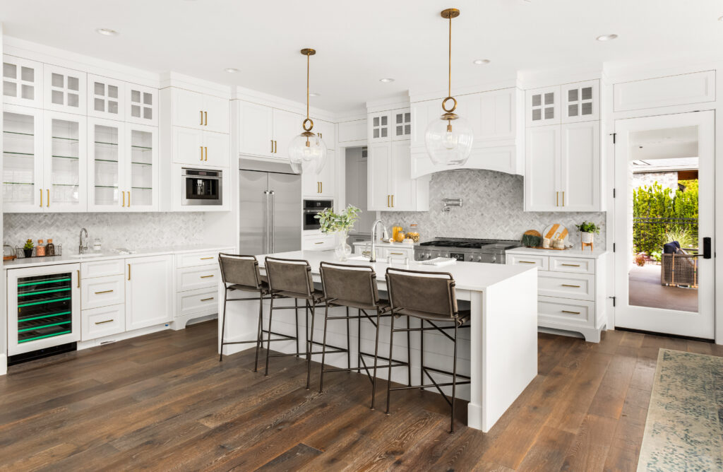 Leave room in your Barndominium cost budget for all the nice amenities you deserve, like this open concept kitchen with white glass front cabinets, built-in appliances, and center kitchen island.